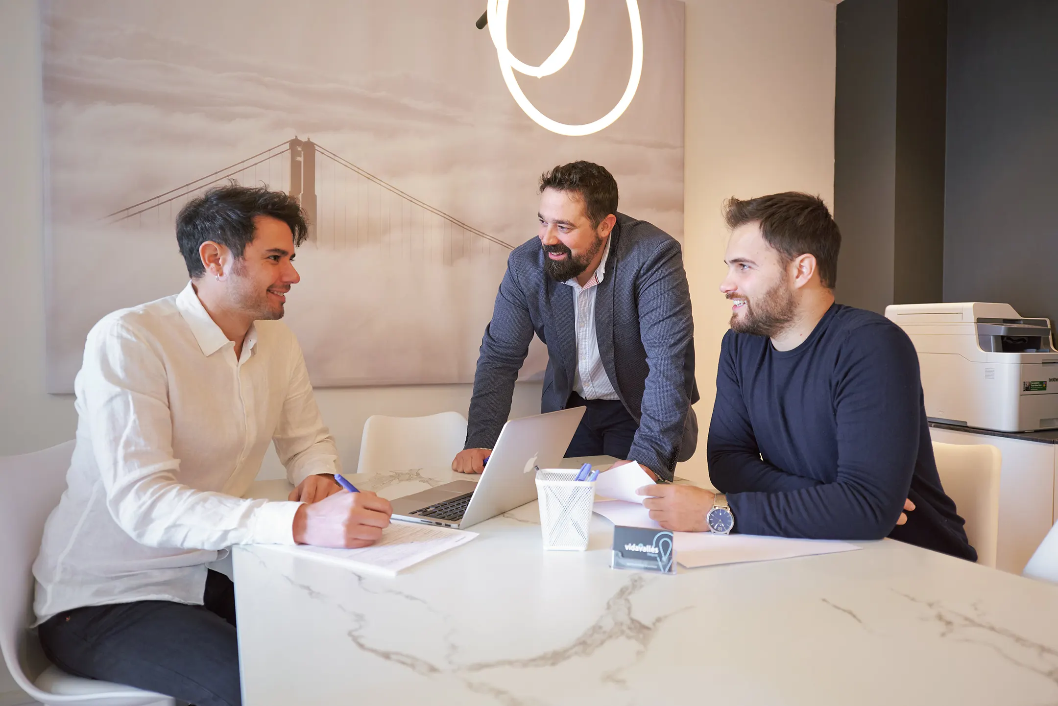 Un equipo comprometido en una inmobiliaria, revisando contratos con atención meticulosa. Nuestra dedicación se refleja en un servicio excepcional para cada cliente.